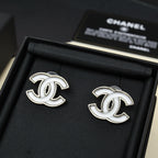 Chanel CC logo stud earrings, silver-tone with white enamel, on black fabric pad