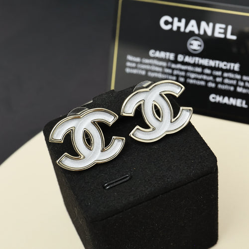 Chanel CC logo enamel earrings with gold-tone frames on black jewelry display