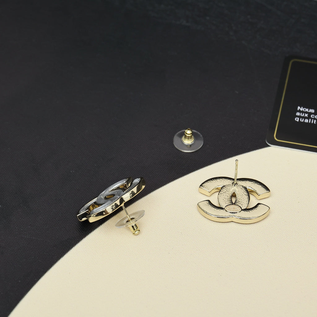 Chanel CC logo stud earrings, gold-tone backs visible with gift box packaging