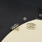 Chanel CC logo stud earrings, gold-tone backs visible with gift box packaging