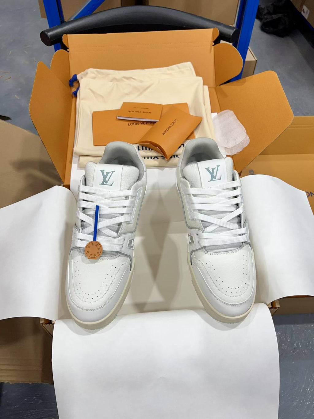 White Louis Vuitton trainer sneakers with lace-up laces and LV heel logos, pair view