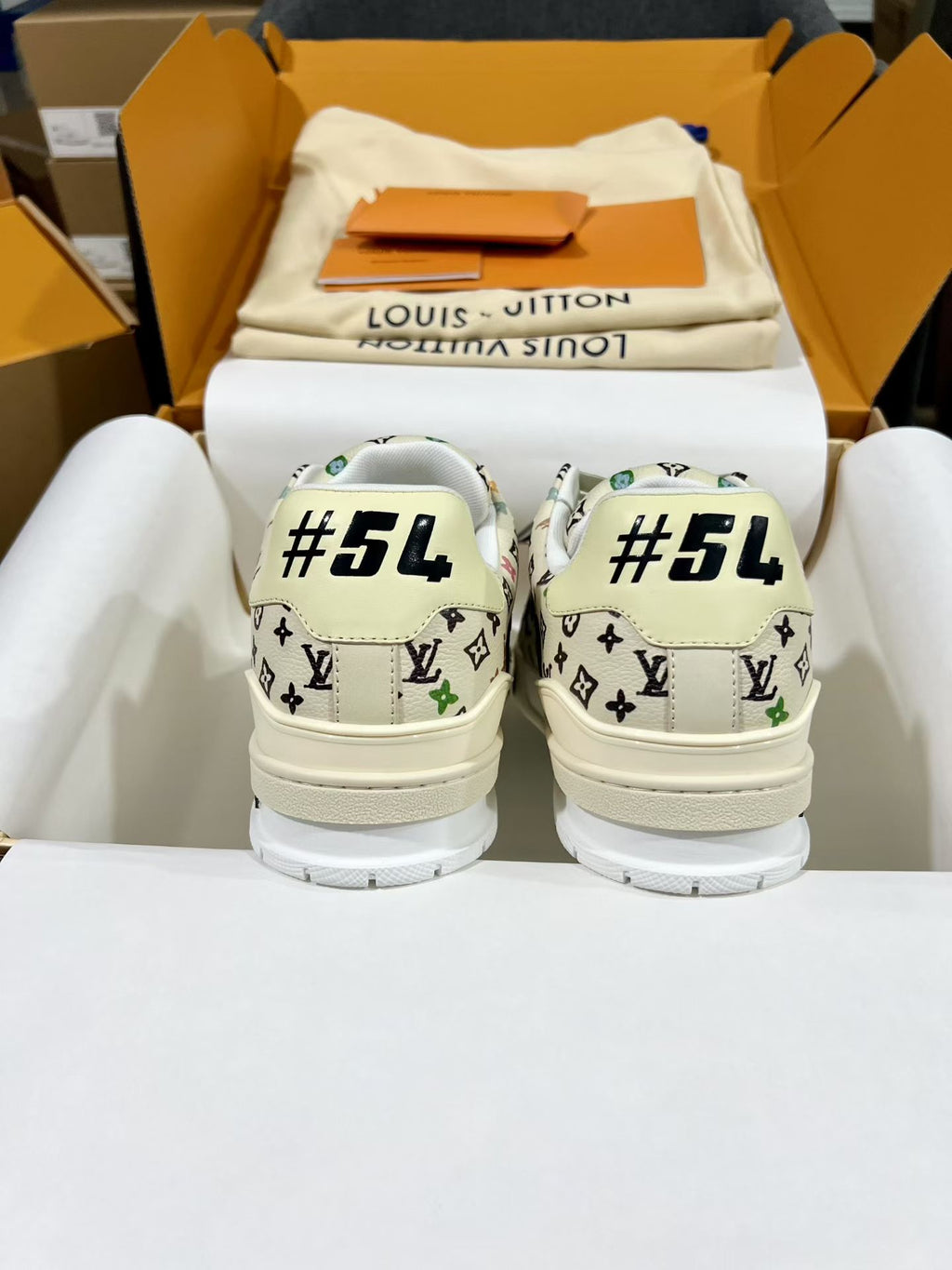 Louis Vuitton sneakers with white monogram print and “#54” text on the heel backs