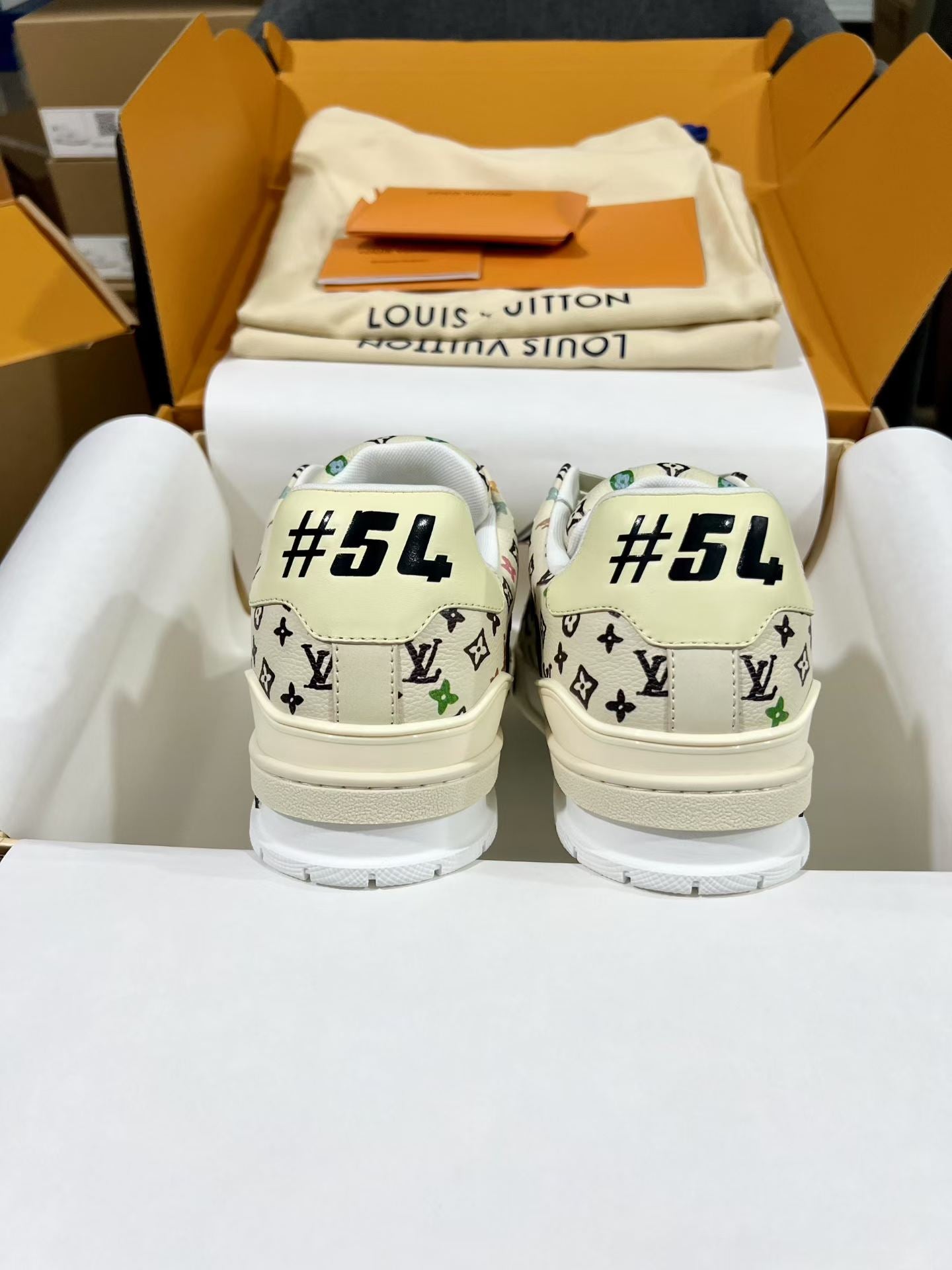 Louis Vuitton sneakers with white monogram print and “#54” text on the heel backs