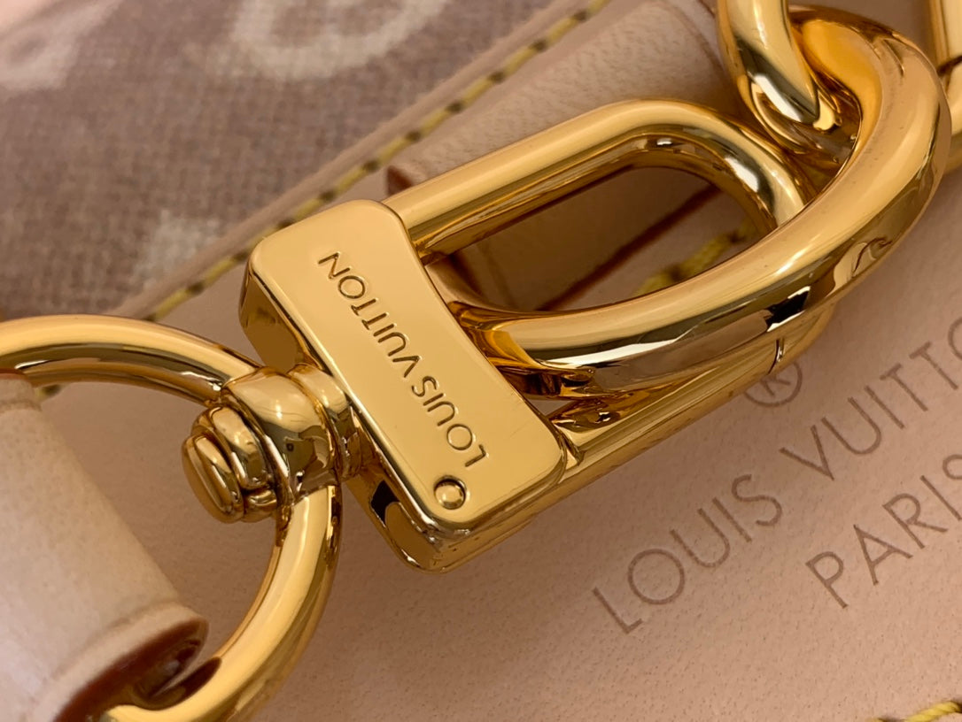 Louis Vuitton gold clasp hardware with engraved text on monogram fabric