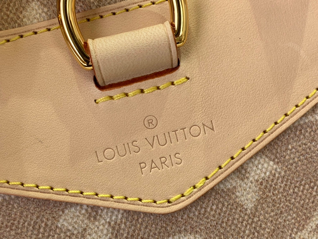 Louis Vuitton embossed label on tan leather edge with yellow stitching and gold hardware