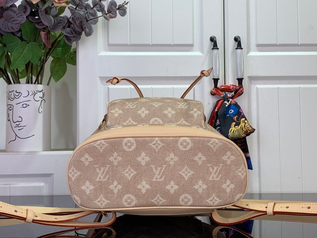 Louis Vuitton monogram backpack with wide rounded body, tan trim, and adjustable straps