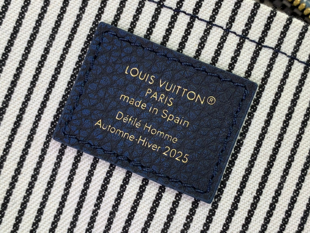 Navy fabric tag: Louis Vuitton Paris, made in Spain, Defile Homme Hiver 2025.