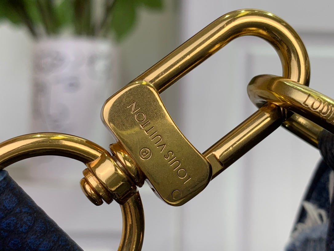 Gold metal clasp with engraved text on dark blue strap hardware.