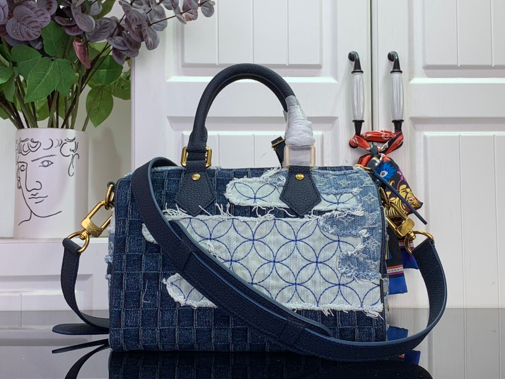 Blue denim patchwork handbag with top handles and crossbody strap; gold hardware.