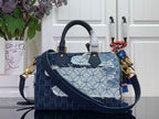 Blue denim patchwork handbag with top handles and crossbody strap; gold hardware.
