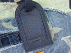 Dark blue leatherette bag tag with embossed pattern on denim fabric.