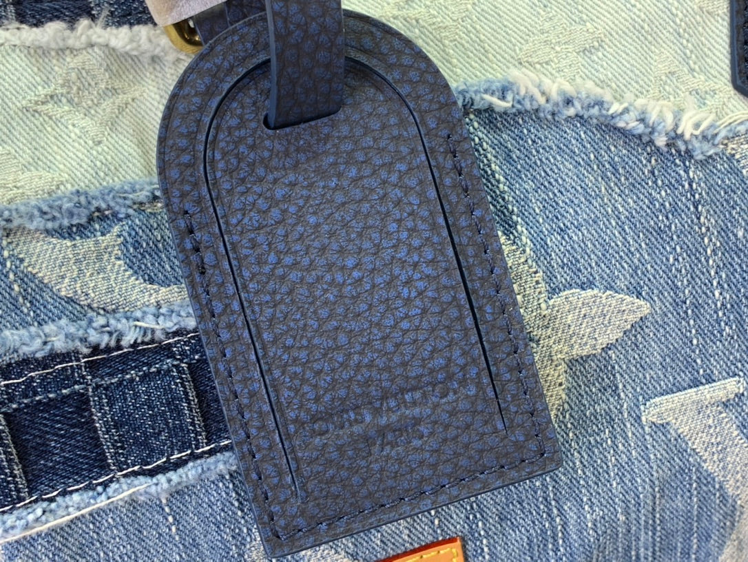 Dark blue leatherette bag tag with embossed pattern on denim fabric.