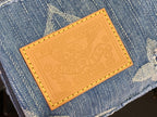Louis Vuitton tan leather logo patch with stitched border on blue denim bag
