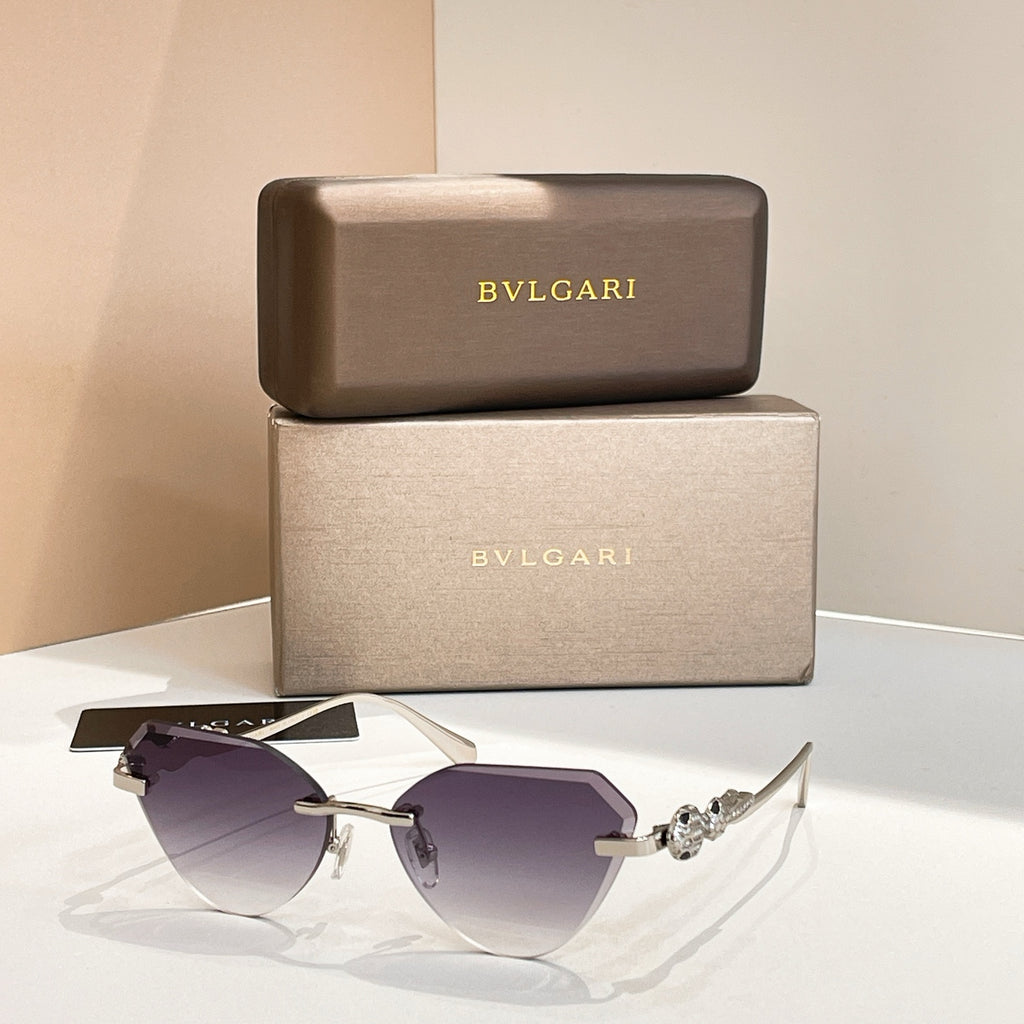 Gold-tone cat-eye sunglasses with deep purple gradient lenses and decorative hinge detail