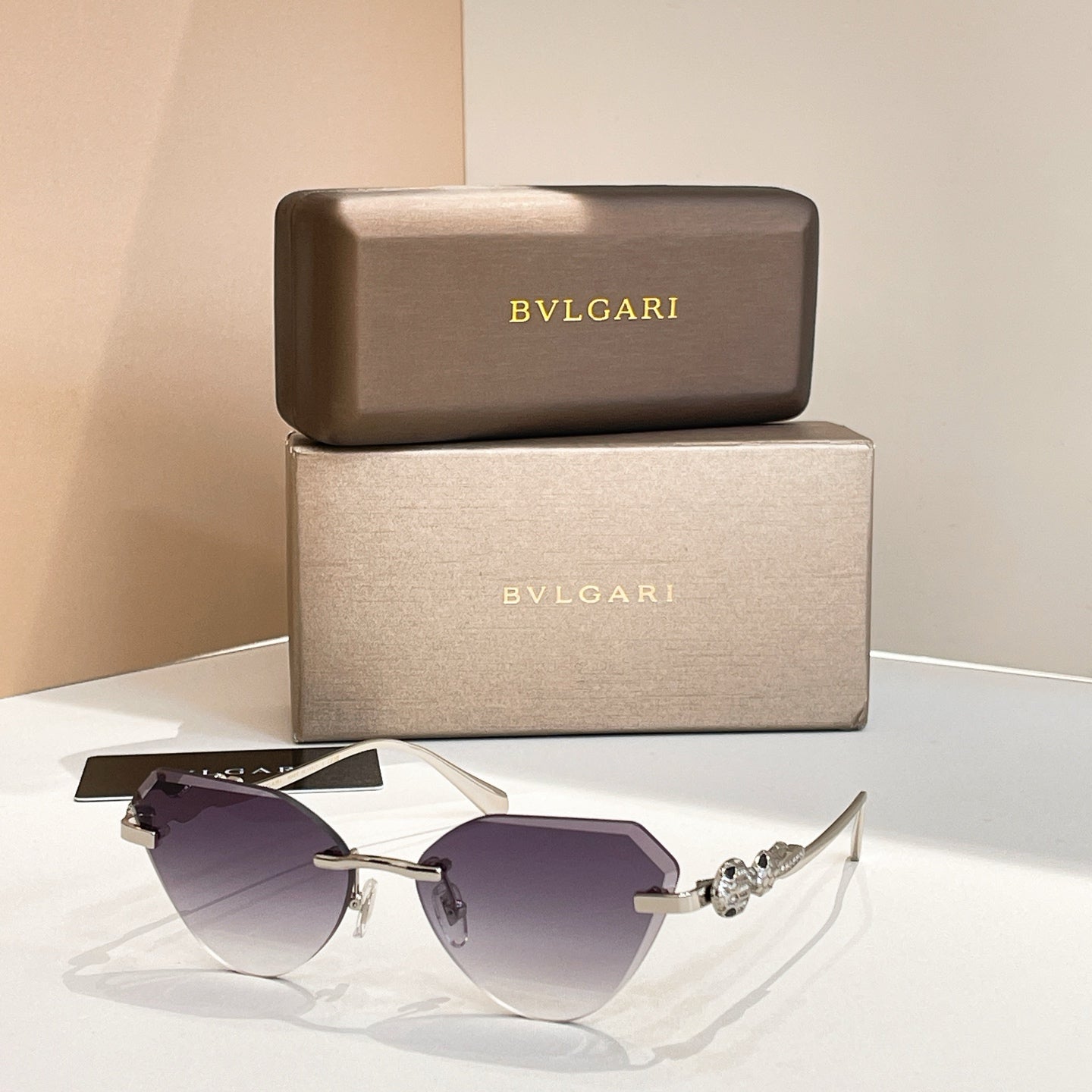 Gold-tone cat-eye sunglasses with deep purple gradient lenses and decorative hinge detail