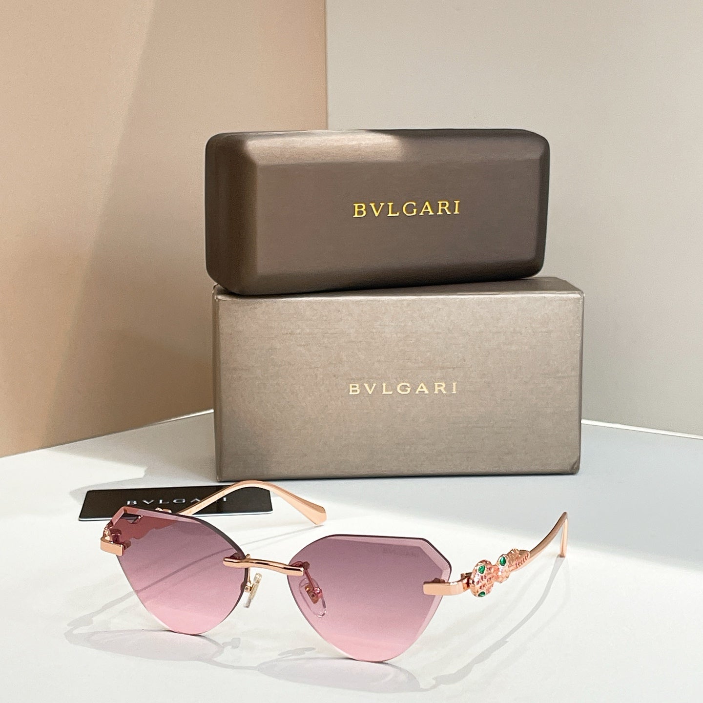 Gold-tone cat-eye sunglasses with pink gradient lenses and decorative hinge detail