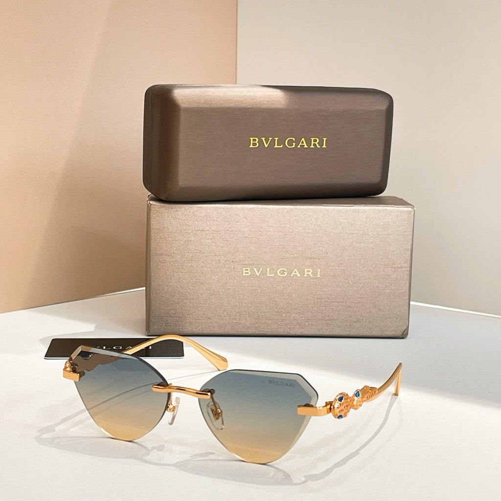 Gold-tone cat-eye sunglasses with light blue gradient lenses and decorative hinge detail