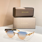 Gold-tone cat-eye sunglasses with blue gradient lenses and decorative hinge detail