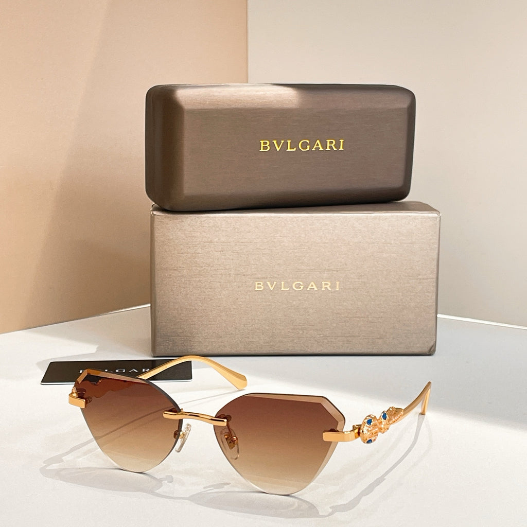 Gold-tone cat-eye sunglasses with brown gradient lenses and decorative hinge detail