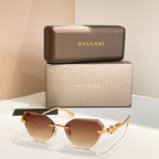 Gold-tone cat-eye sunglasses with brown gradient lenses and decorative hinge detail