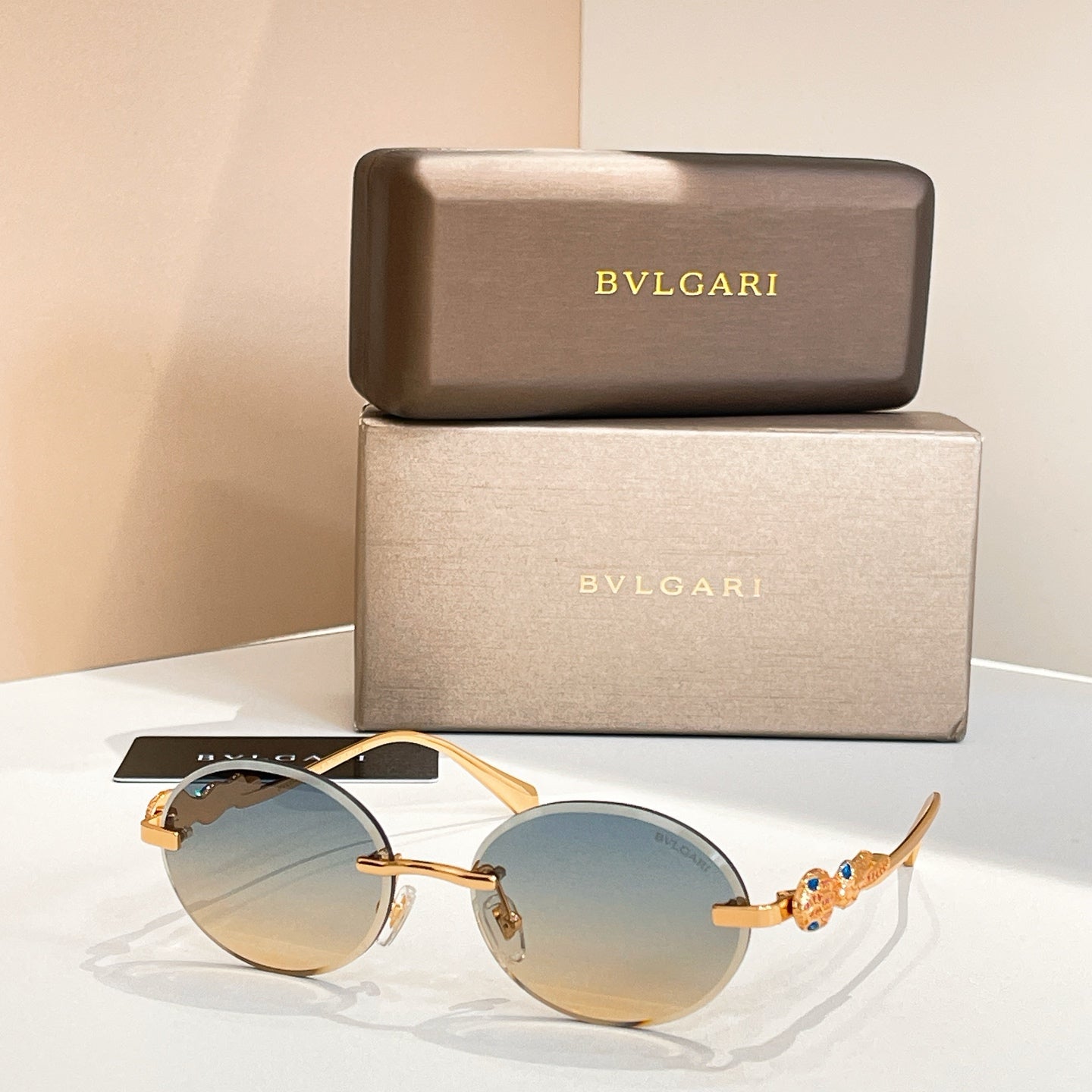 Bvlgari round sunglasses with gold-tone frame and light blue tinted lenses