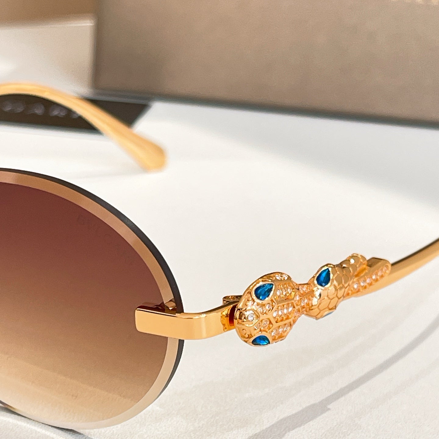 Bvlgari sunglasses with gold-tone temple detail and blue gemstone-like accents