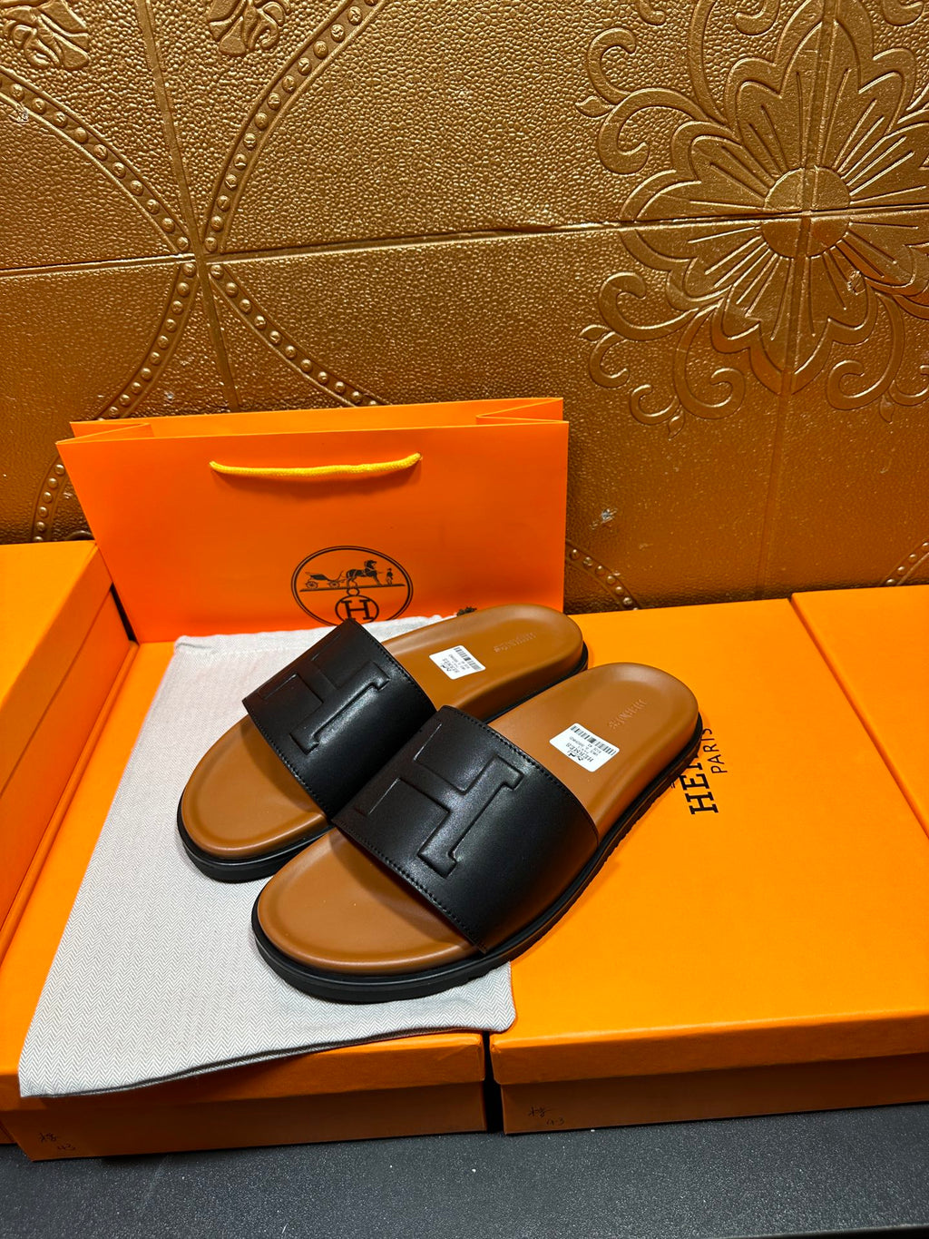 Black leather slide sandals with embossed H logo straps