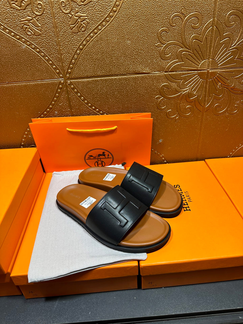 Black leather slide sandals with wide H strap, flat sole