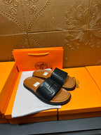Black leather slide sandals with wide H strap, flat sole