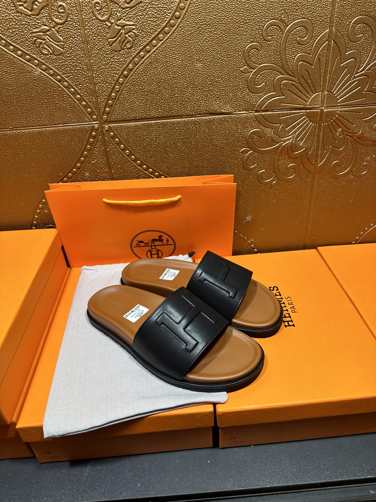 Black leather slide sandals with wide H strap, flat sole