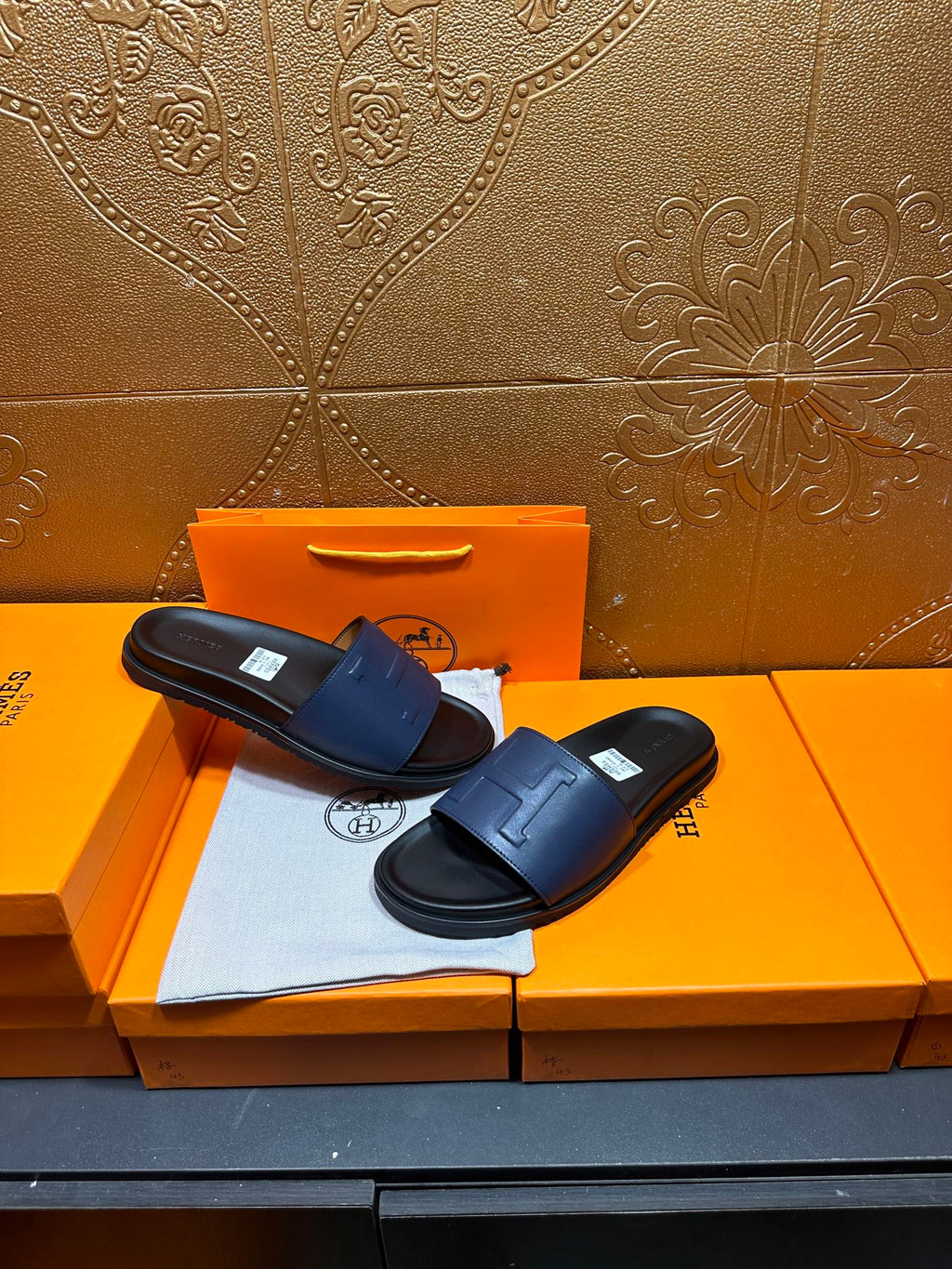 Pair of leather slide sandals, wide strap design with H-shaped stitch detail