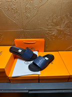 Pair of leather slide sandals, wide strap design with H-shaped stitch detail