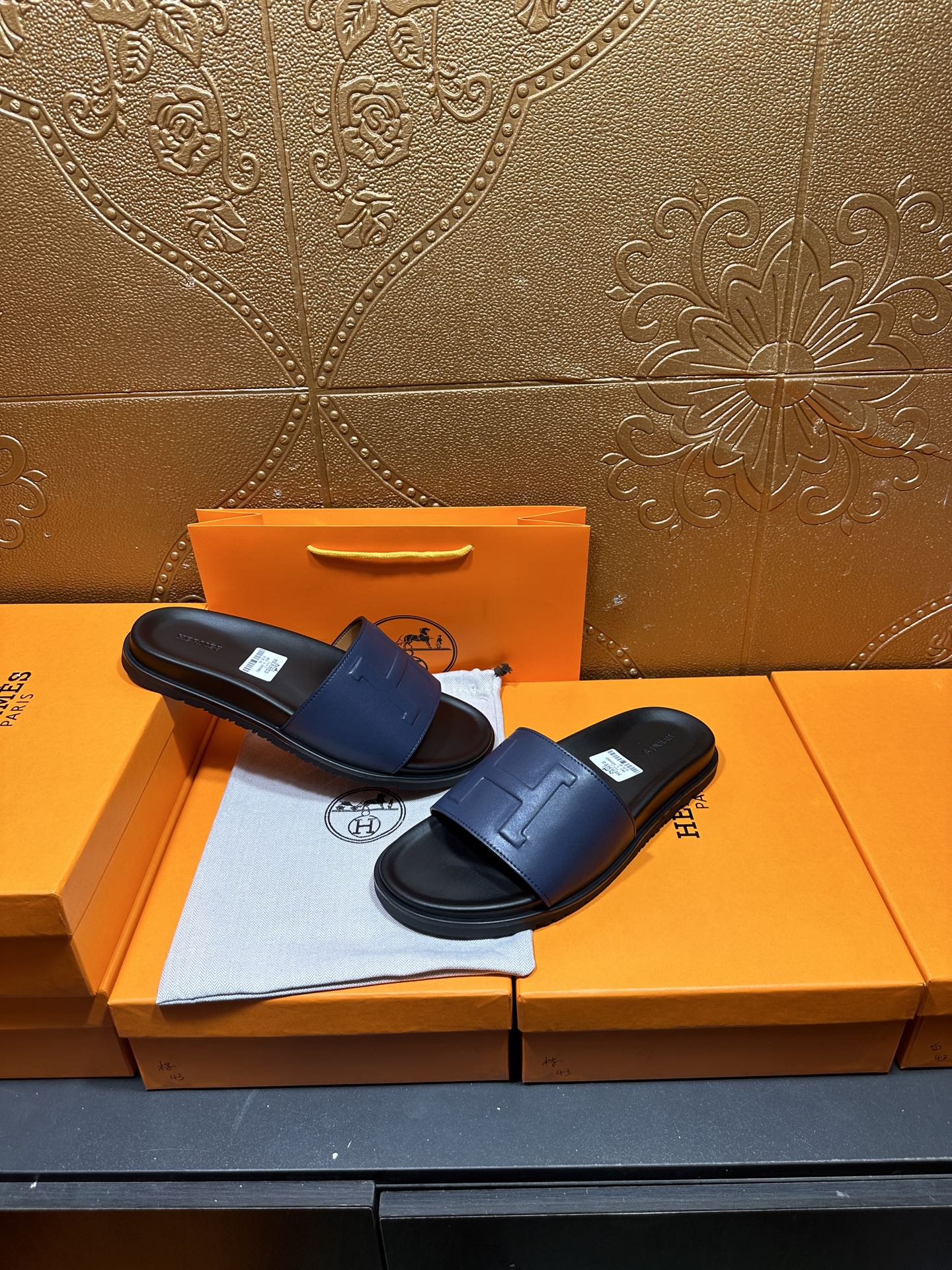 Pair of leather slide sandals, wide strap design with H-shaped stitch detail