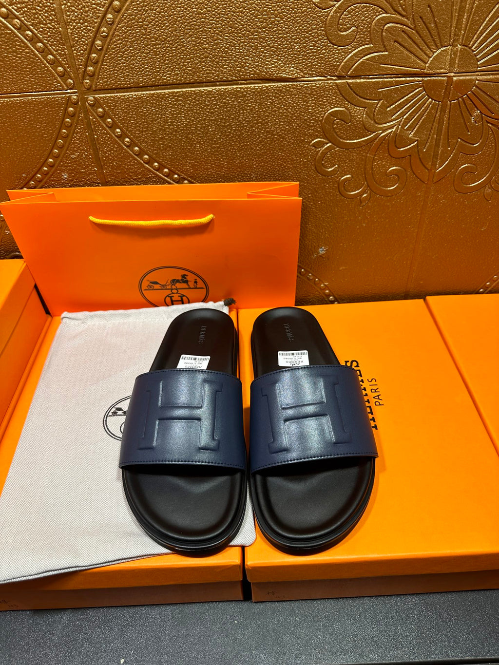 Leather slide sandals with wide strap and stitched H detail, dark sole