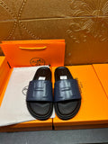 Leather slide sandals with wide strap and stitched H detail, dark sole