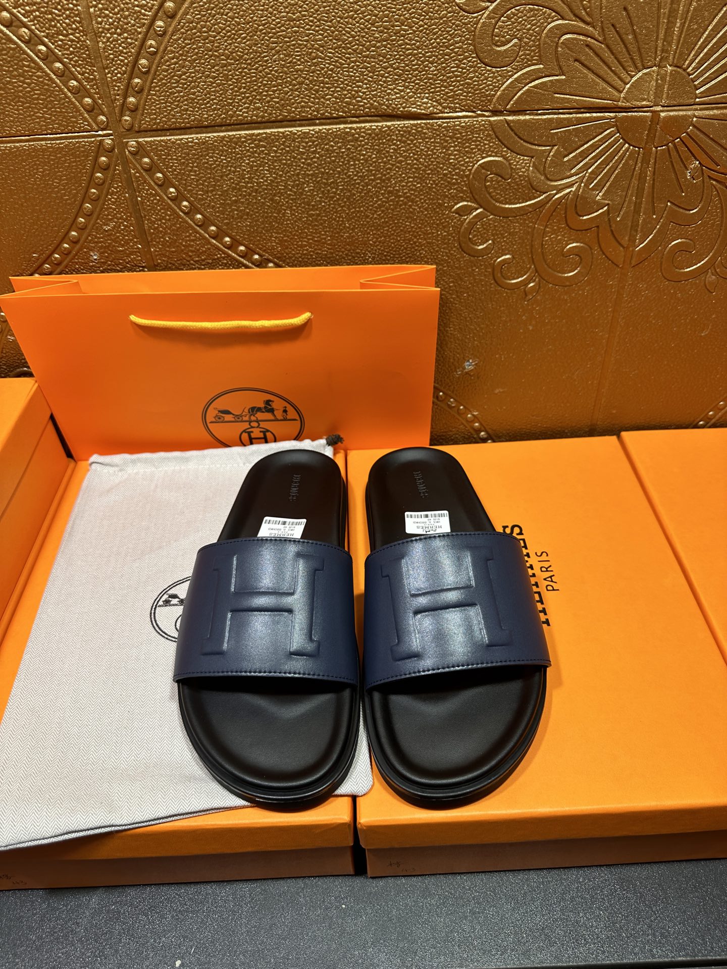 Leather slide sandals with wide strap and stitched H detail, dark sole