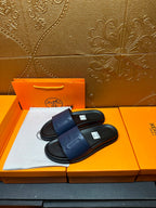 Pair of leather slide sandals with wide front strap and H-shaped stitch detail