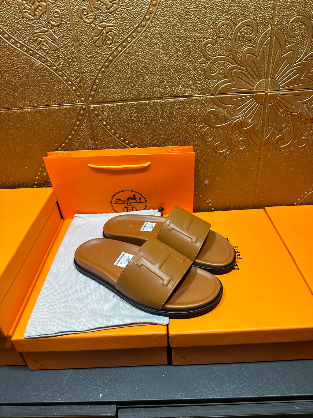 Tan leather Hermes slide sandals with wide strap and square buckle, pair on box