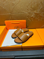 Tan leather Hermes slide sandals, pair displayed on box with square buckle strap