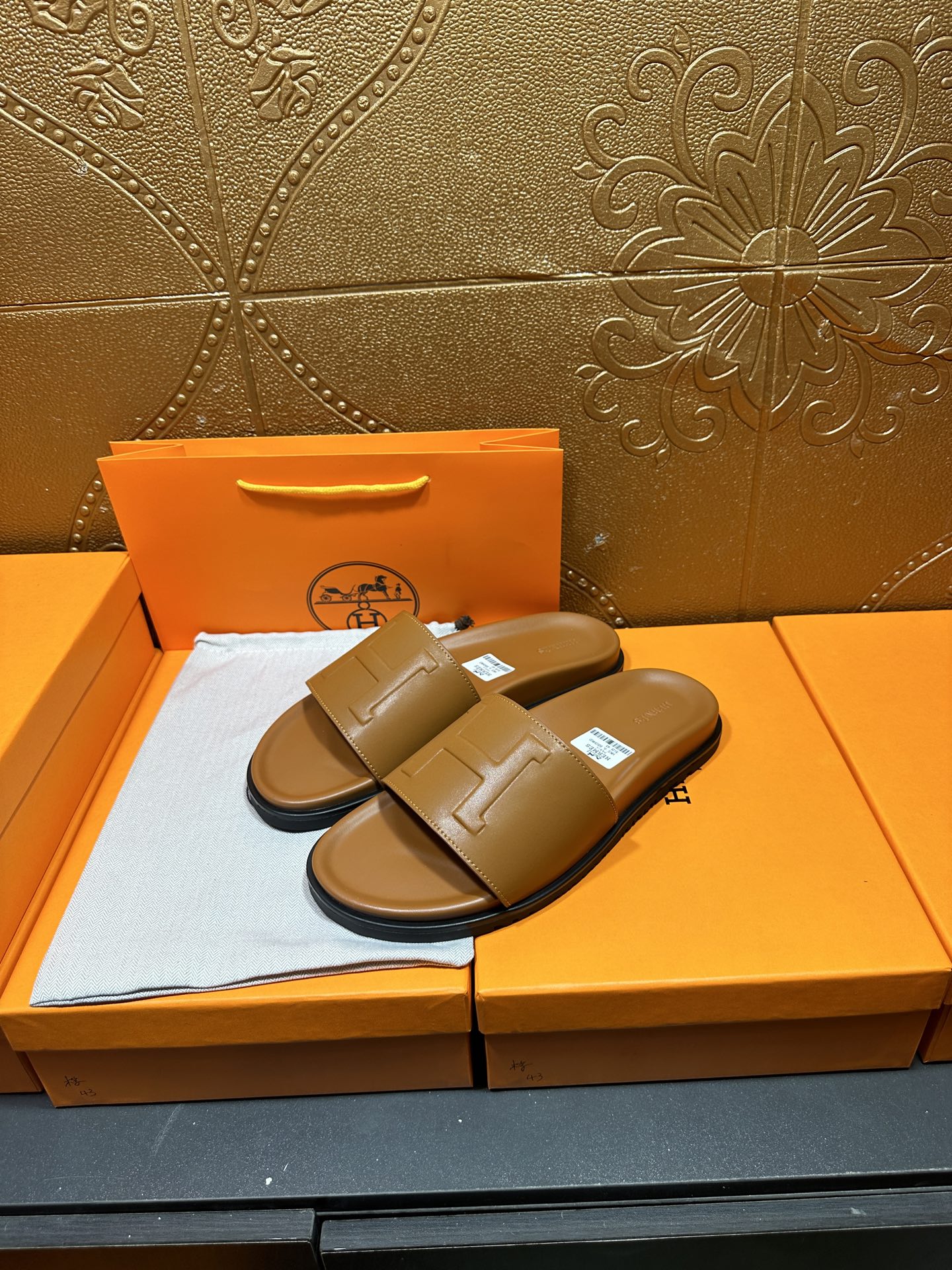 Tan leather Hermes slide sandals, pair displayed on box with square buckle strap
