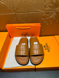 Tan leather Hermes slide sandals with square buckle strap and cushioned footbed