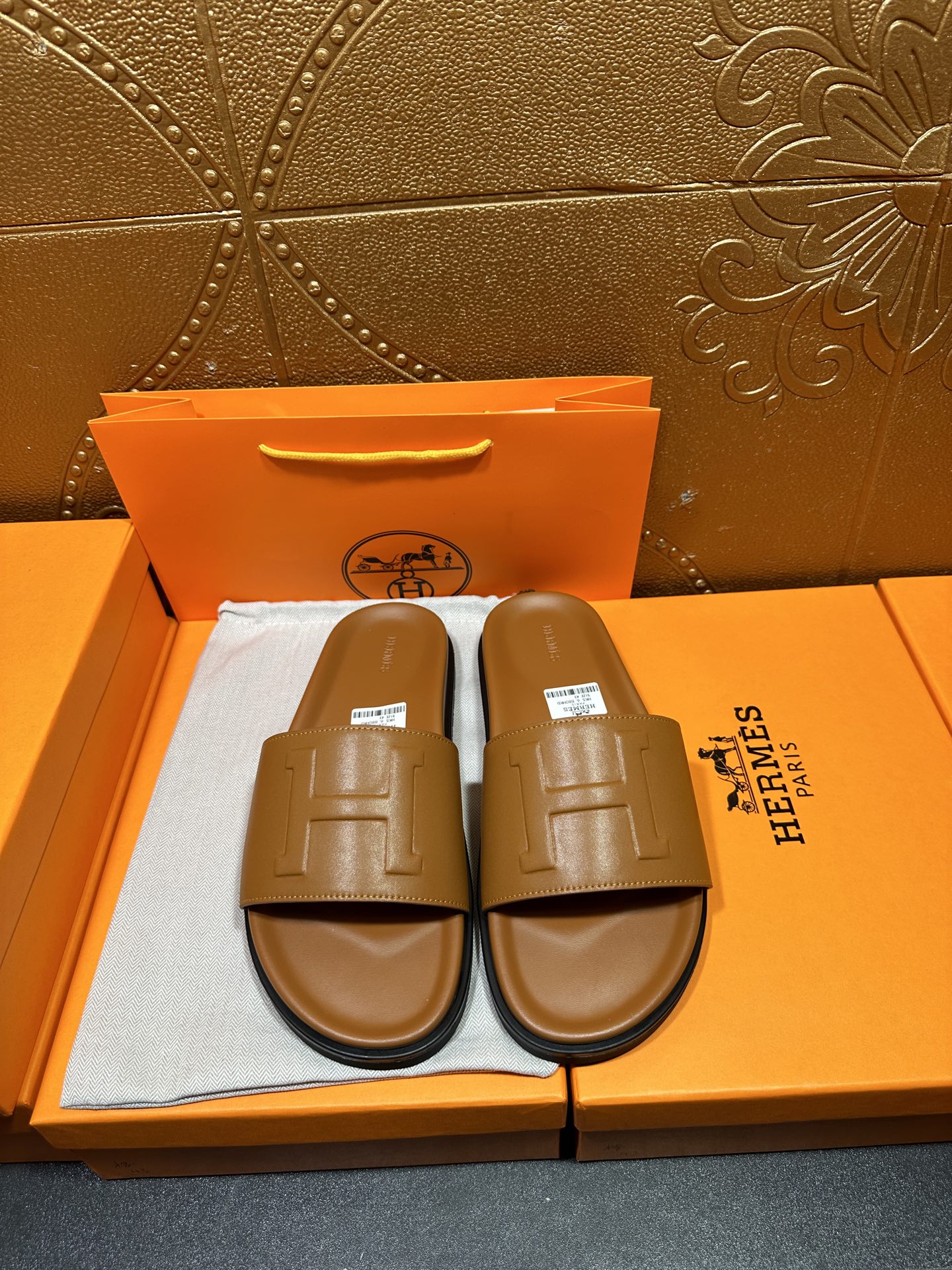 Tan leather Hermes slide sandals with square buckle strap and cushioned footbed