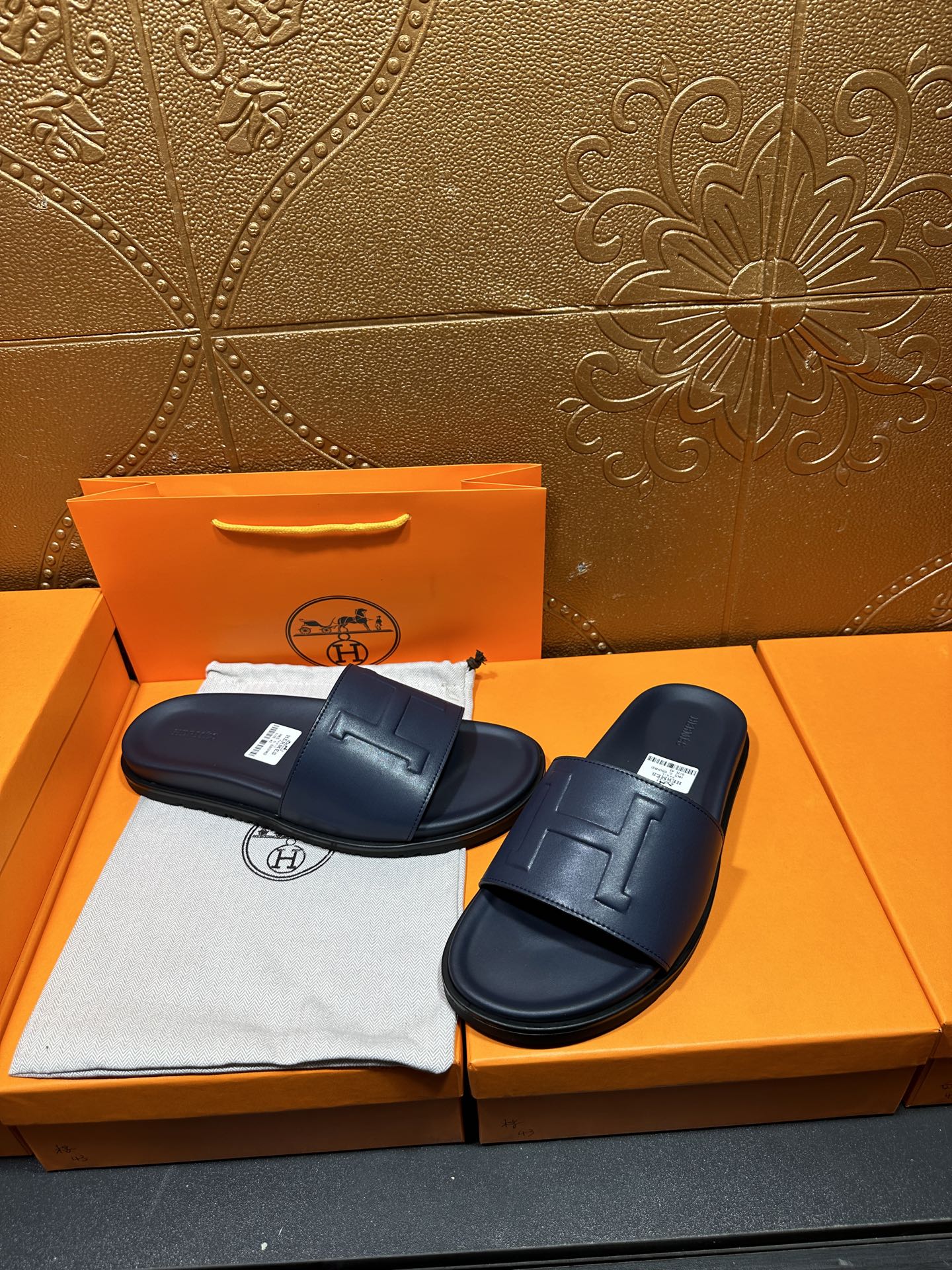 Hermes navy slide sandals, front H buckle detail and contoured footbed