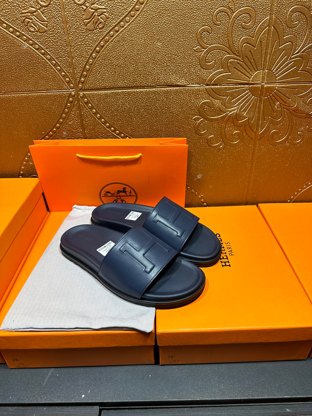 Hermes navy slide sandals with embossed H strap and molded footbed