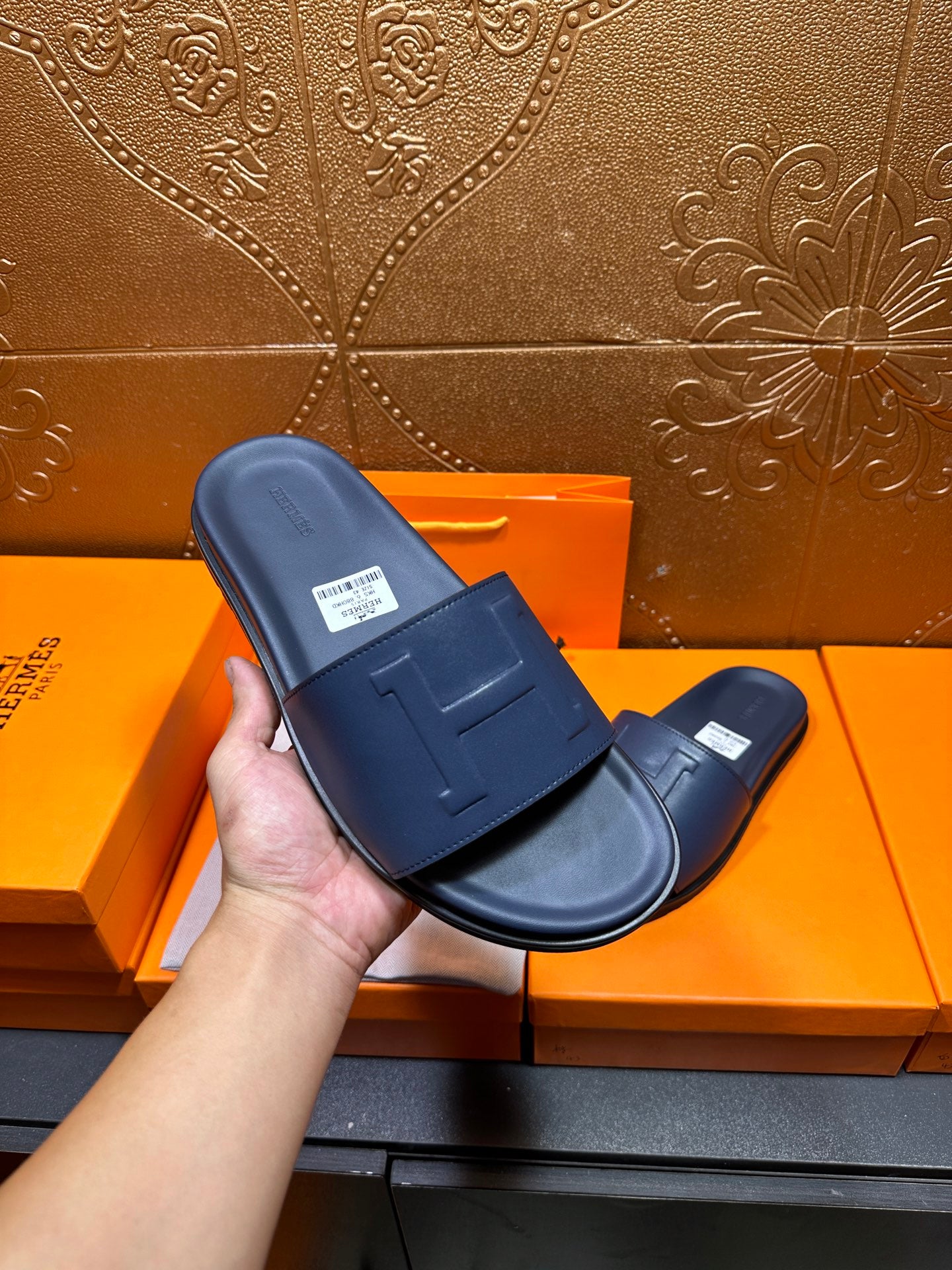 Hermes navy slide sandals close-up of molded H strap and footbed