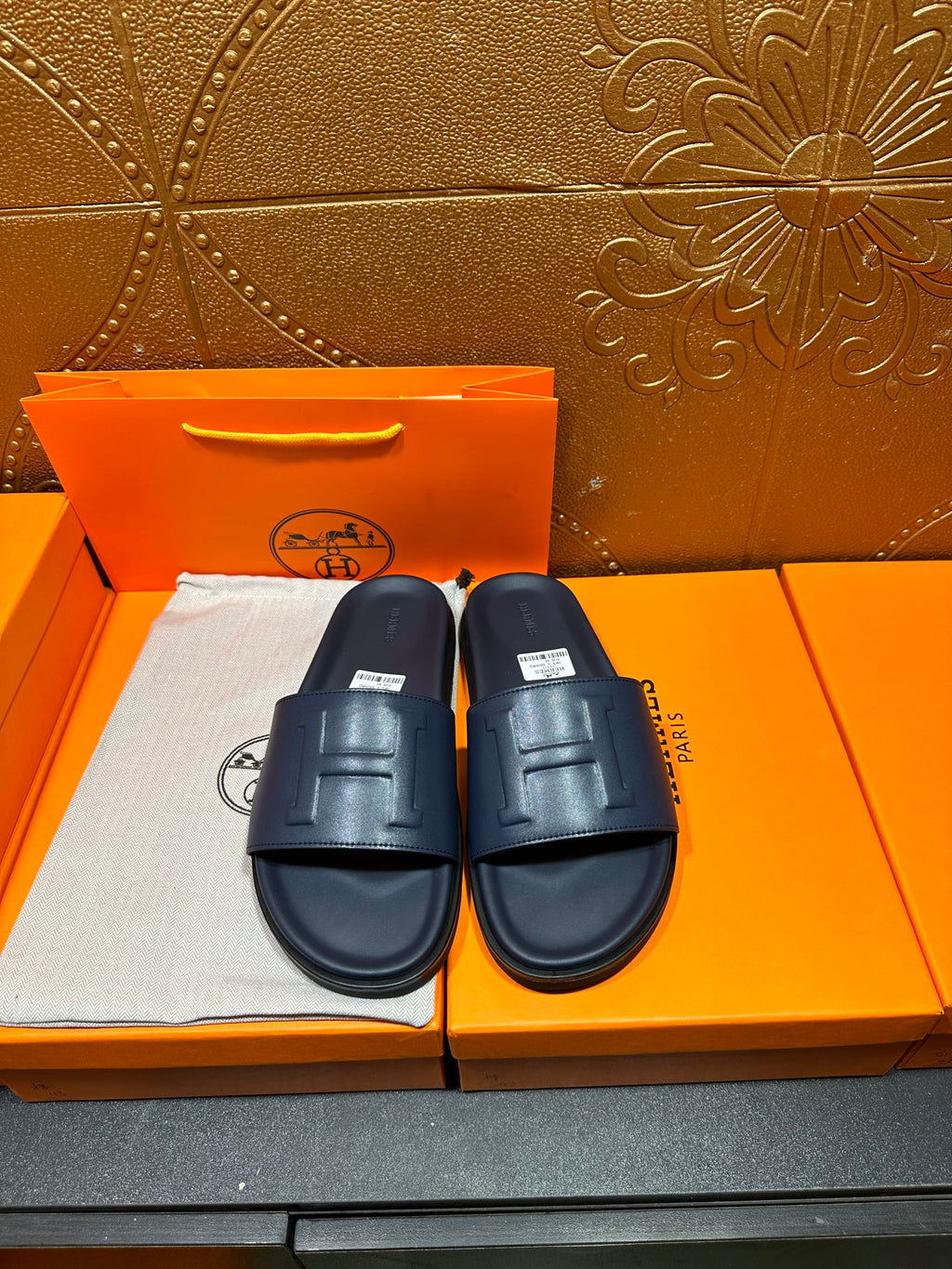 Hermes navy slide sandals with embossed H front strap and cushioned footbed