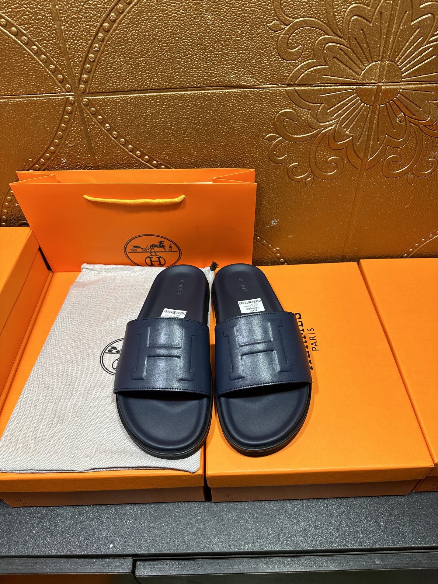 Hermes navy slide sandals with embossed H front strap and cushioned footbed