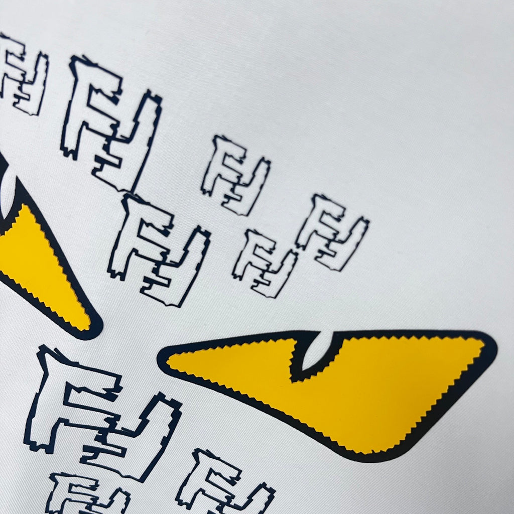 White sweatshirt graphic detail with large yellow eyes and black letter shapes