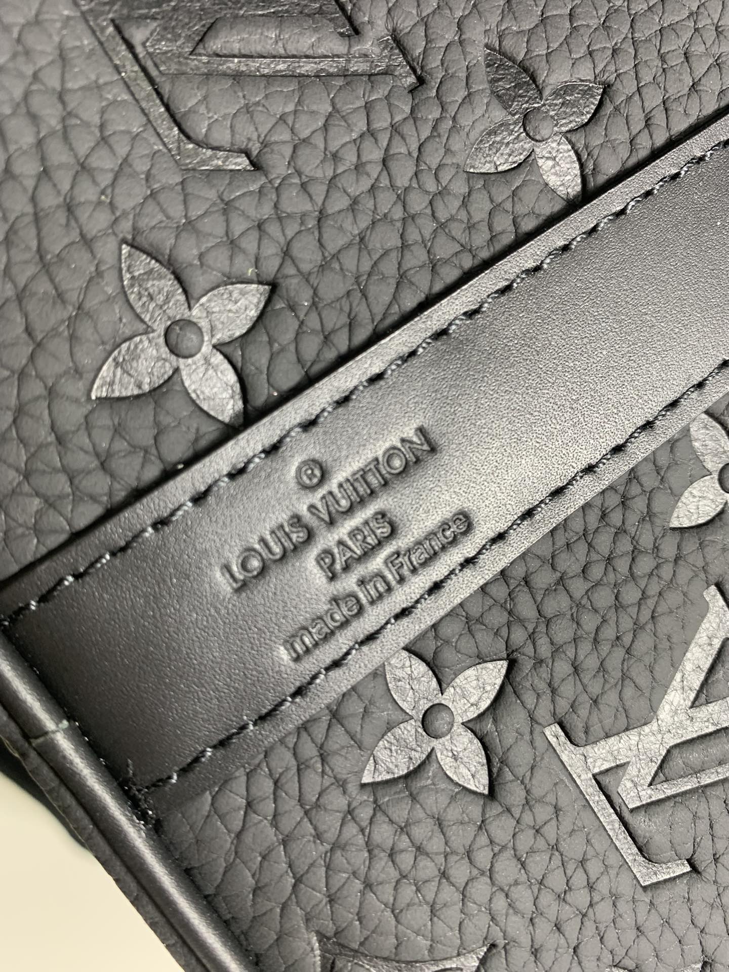 Embossed logo label on monogram duffel bag exterior