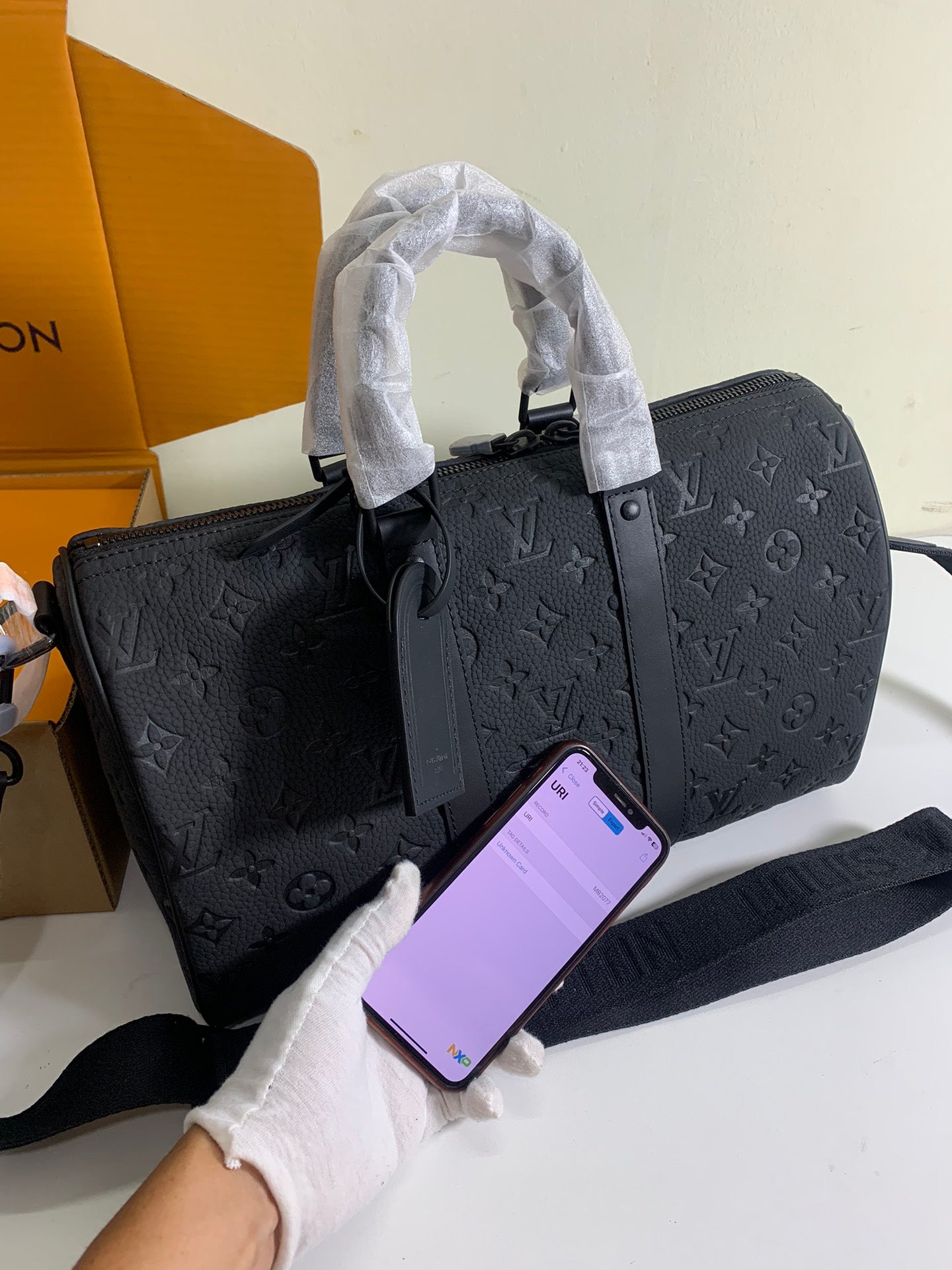 Dark monogram duffel bag with front zip pocket and detachable shoulder strap